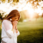 young woman outside praying